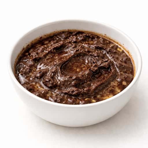 Chocolate ganache in a bowl showing signs of splitting and graininess